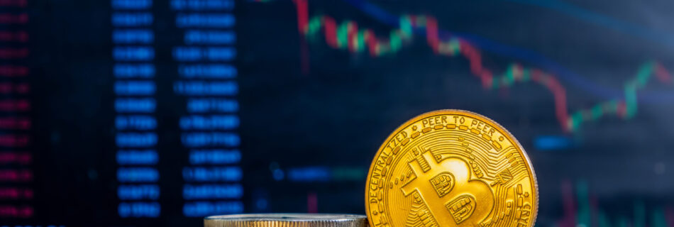 Close-up of golden Bitcoins on a dark reflective surface and the histogram of decreasing crypto in the background